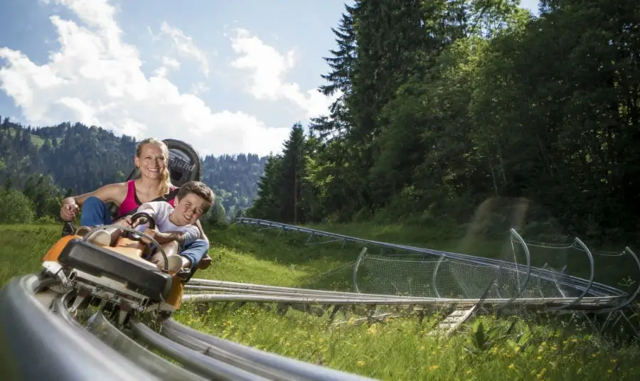 Mother and son on a roller coaster down the mountain at Oberammergau